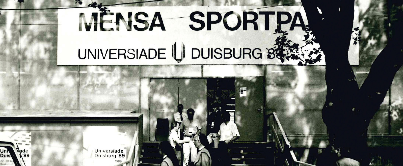 Schwarz-weiß Foto vor dem Eingang zur Mensa in Duisburg während der Universiade 1989.