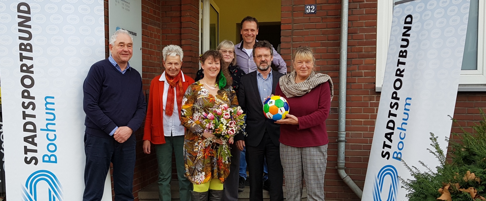 Staatssekretärin Andrea Milz mit den Vorstandsmitgliedern des Sportbunds Bochum vor dem Vereinsgebäude.