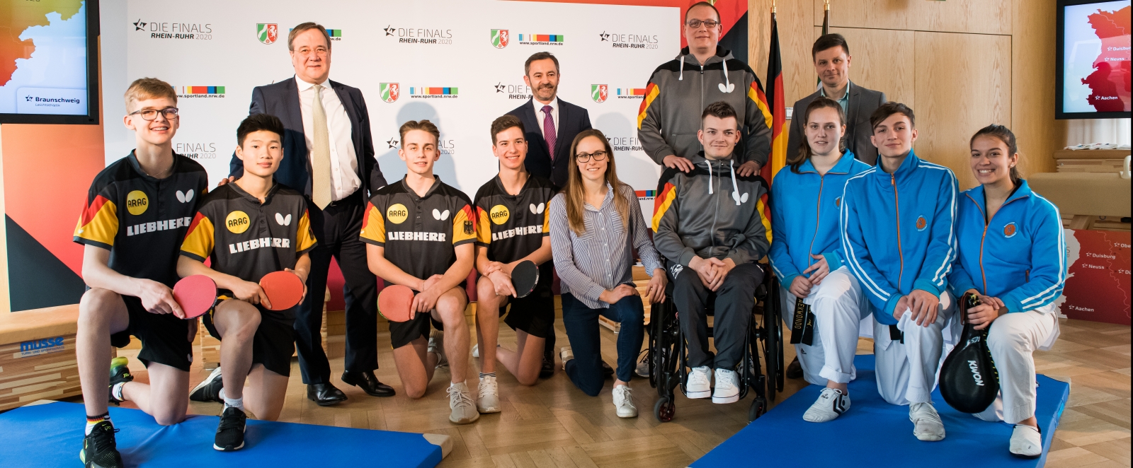 Ministerpräsident Armin Laschet steht mit einem Tischtennisspieler-Team und weiteren Personen zusammen für ein Portraitbild.