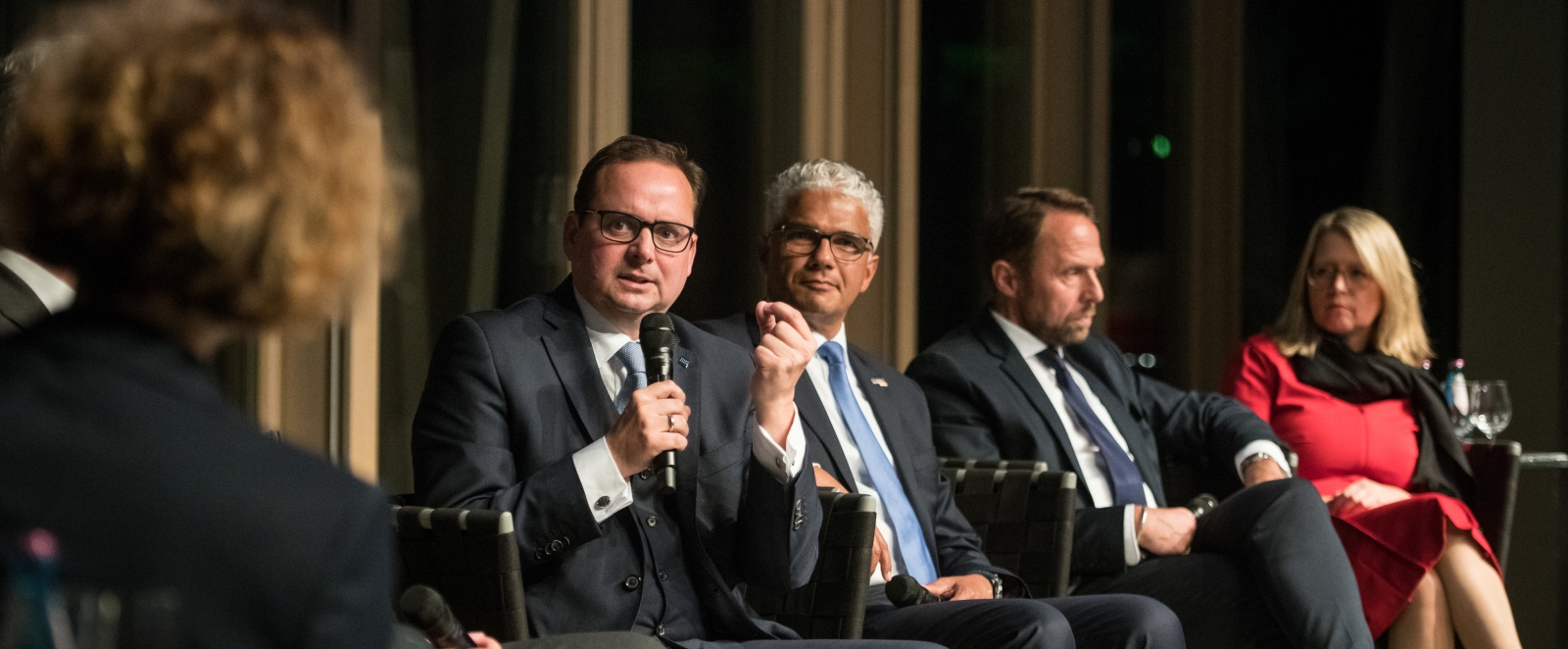 Man sieht 5 Personen im Halbkreis in einer Diskussionsrunde sitzen.