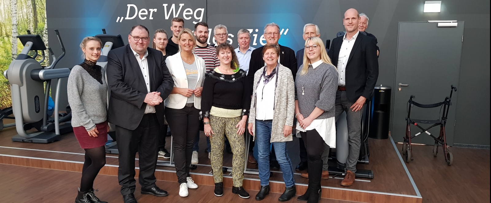Gruppenfoto mit Staatssekretärin Andrea MIlz, auf der Rückwand steht weiß auf grau: "Der Weg ist das Ziel!"