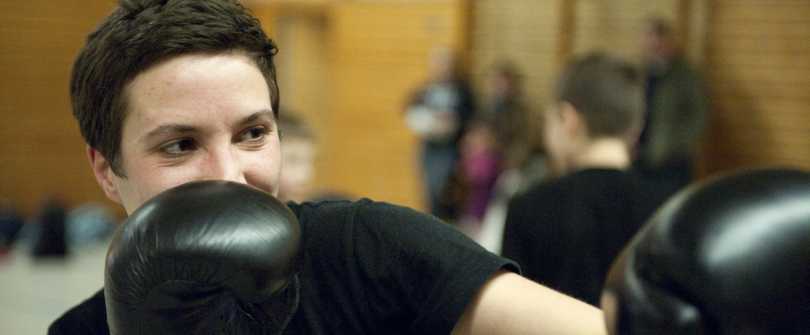 Frau in Sporthalle mit Boxhandschuhen