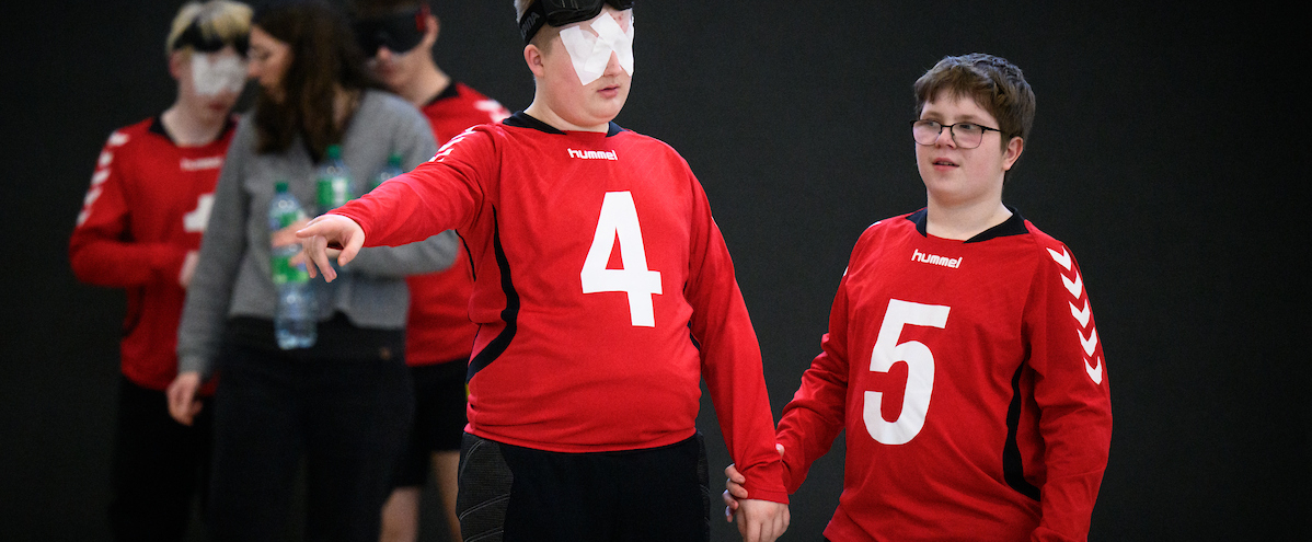 Junge Goalballer in roten Trikots