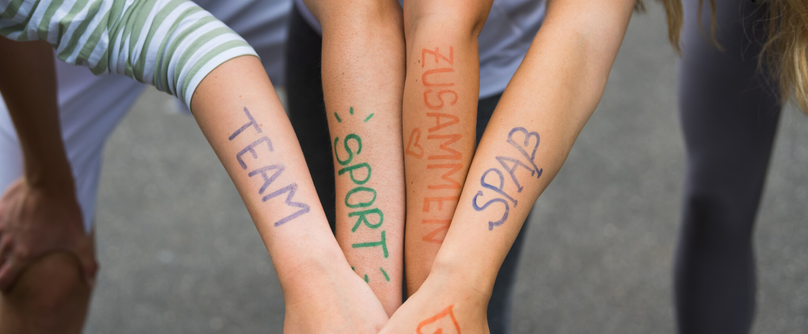 Vier Unterarme mit Schriftzug Team, Sport, Zusammen, Spaß 