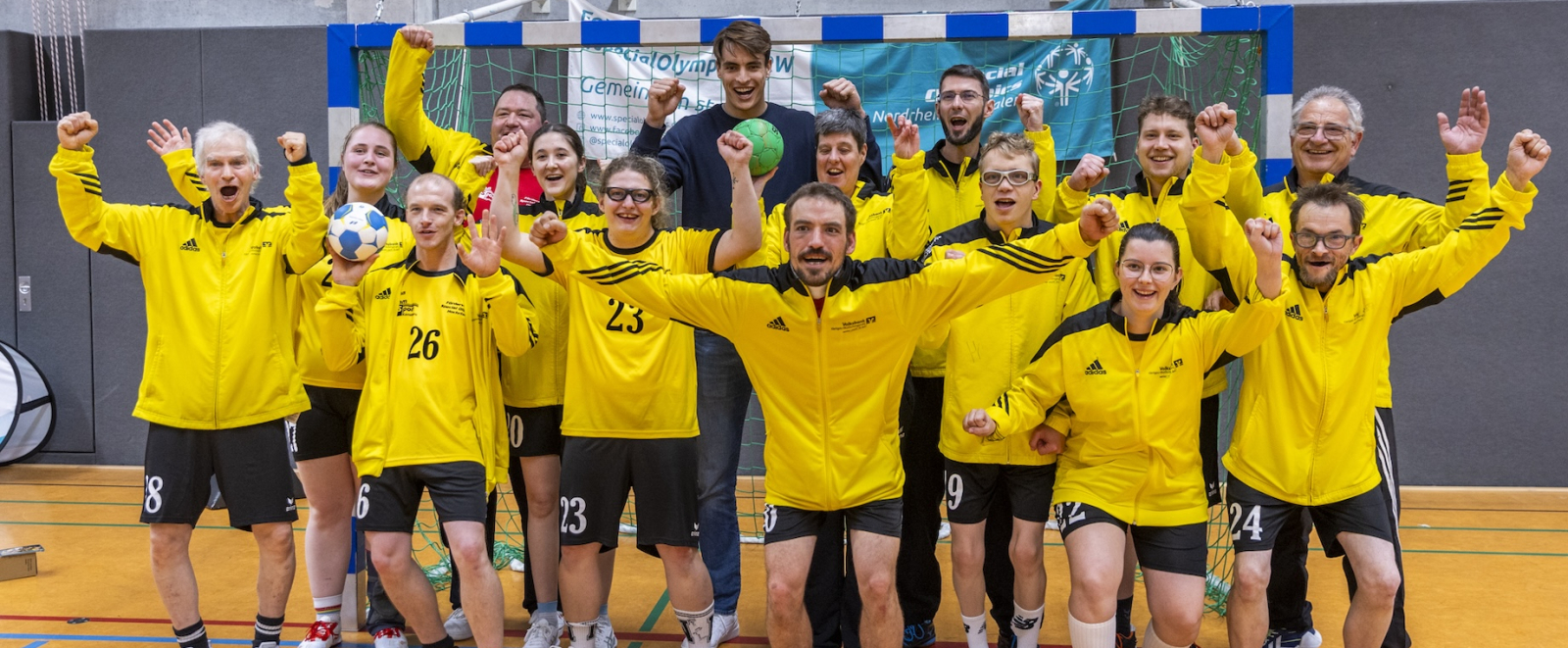 Julian Köster jubelt mit vielen Personen bei einem Handball-Training