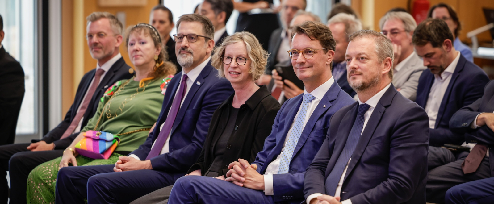 6 Menschen , u.a. Hendrik Wüst und Andrea Milz, sitzen bei einer Veranstaltung