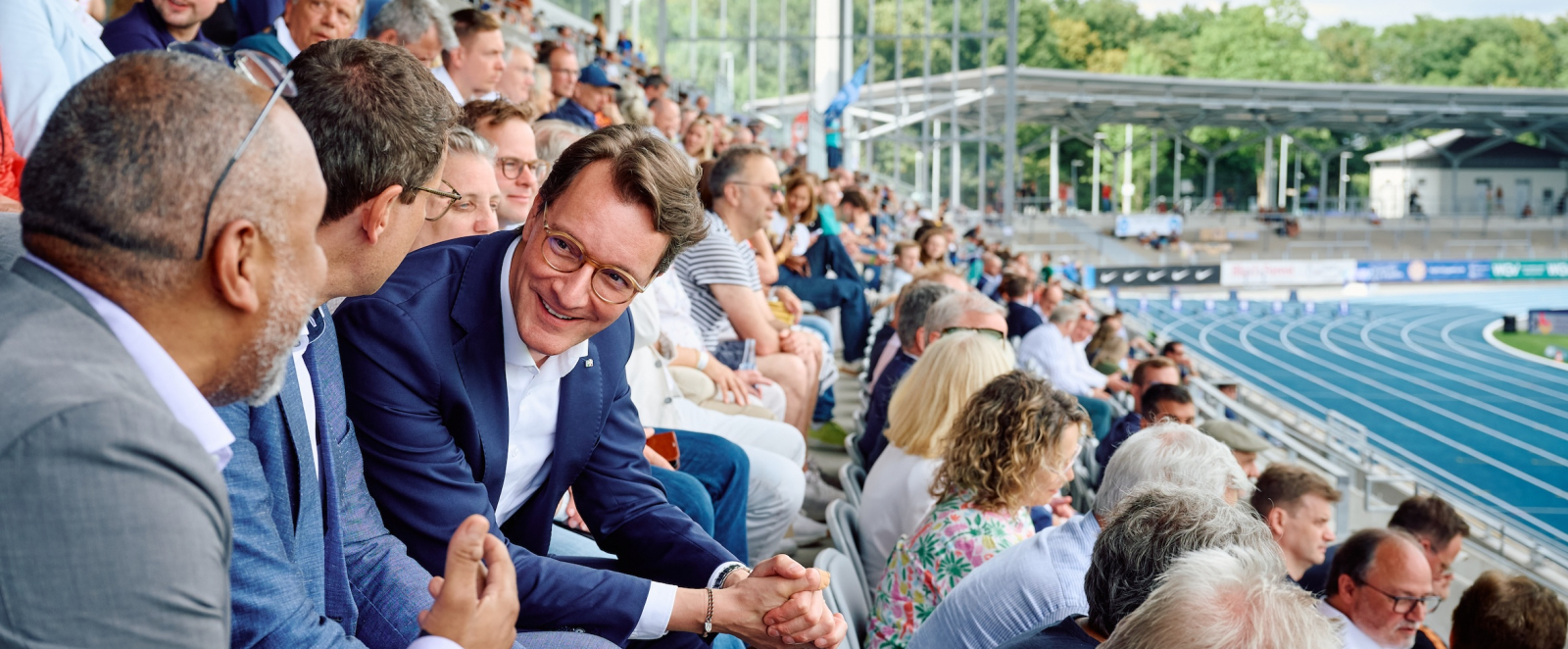 Hendrik Wüst mit weiteren Personen auf Tribüne des Lohrheidestadions