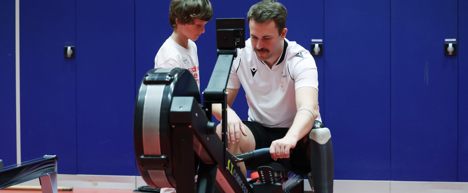 Junge und ein Mann an einem Sportgerät
