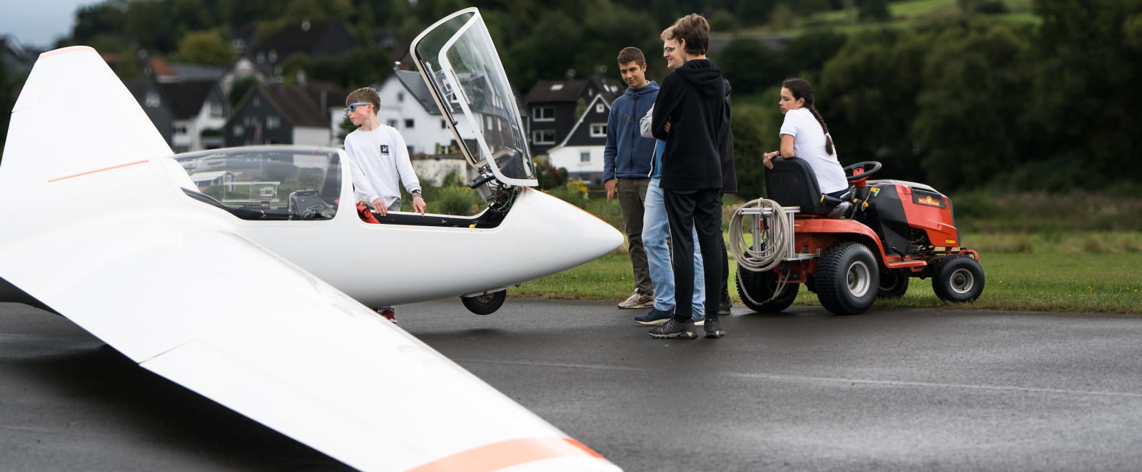 Mehrere Personen stehen um ein Segelflugzeug am Boden herum