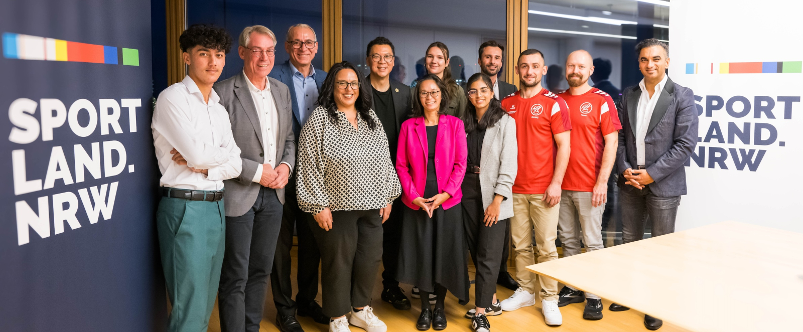Gruppe von Personen neben Sportland.NRW-Banner