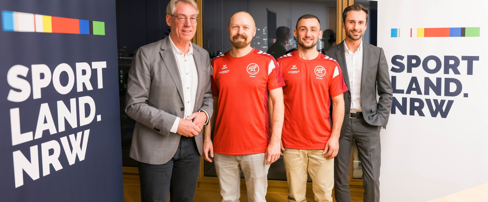 Vier Personen neben Sportland.NRW-Bannern