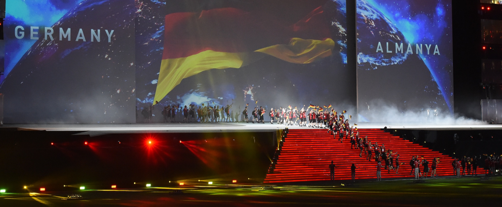 Bühne mit buntem Feuerwerk dahinter, das deutsche Team läuft ein