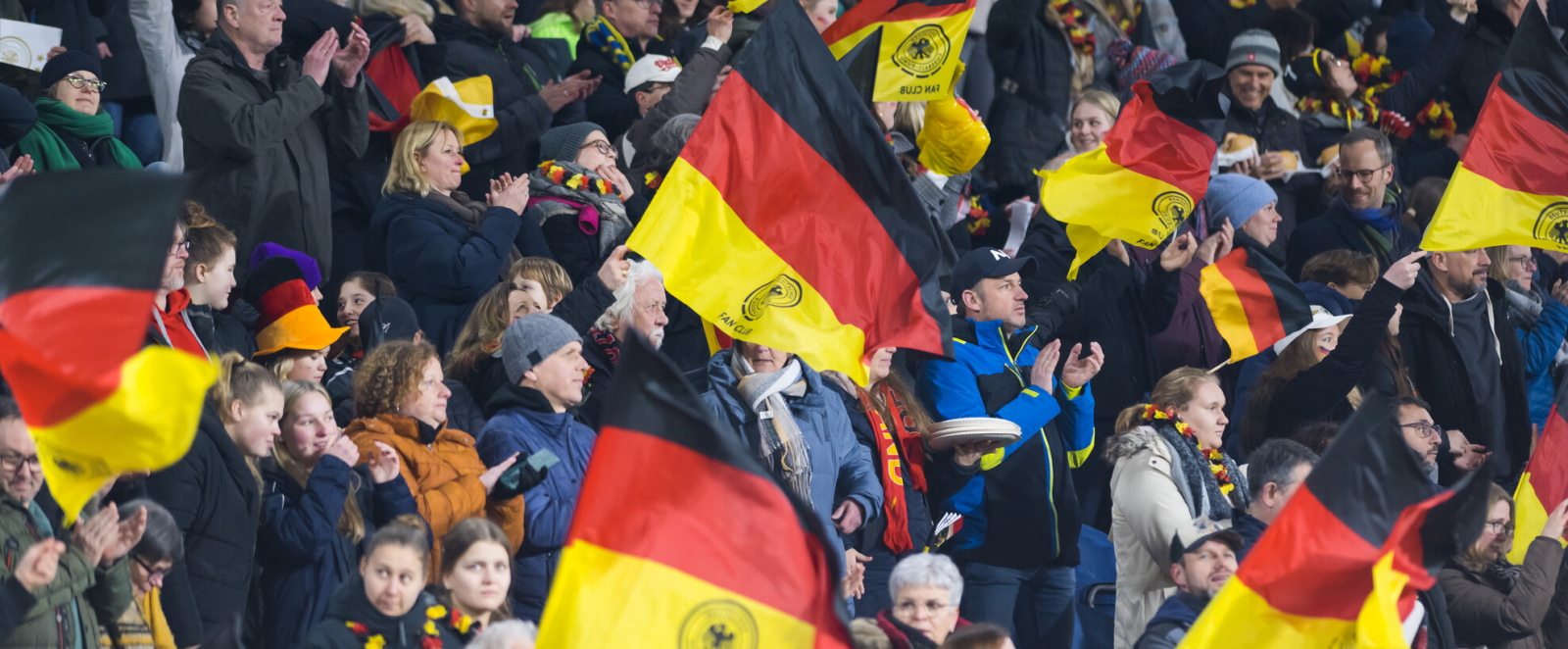 Publikum auf einer Bühne, die Deutschland-Flaggen schwenken