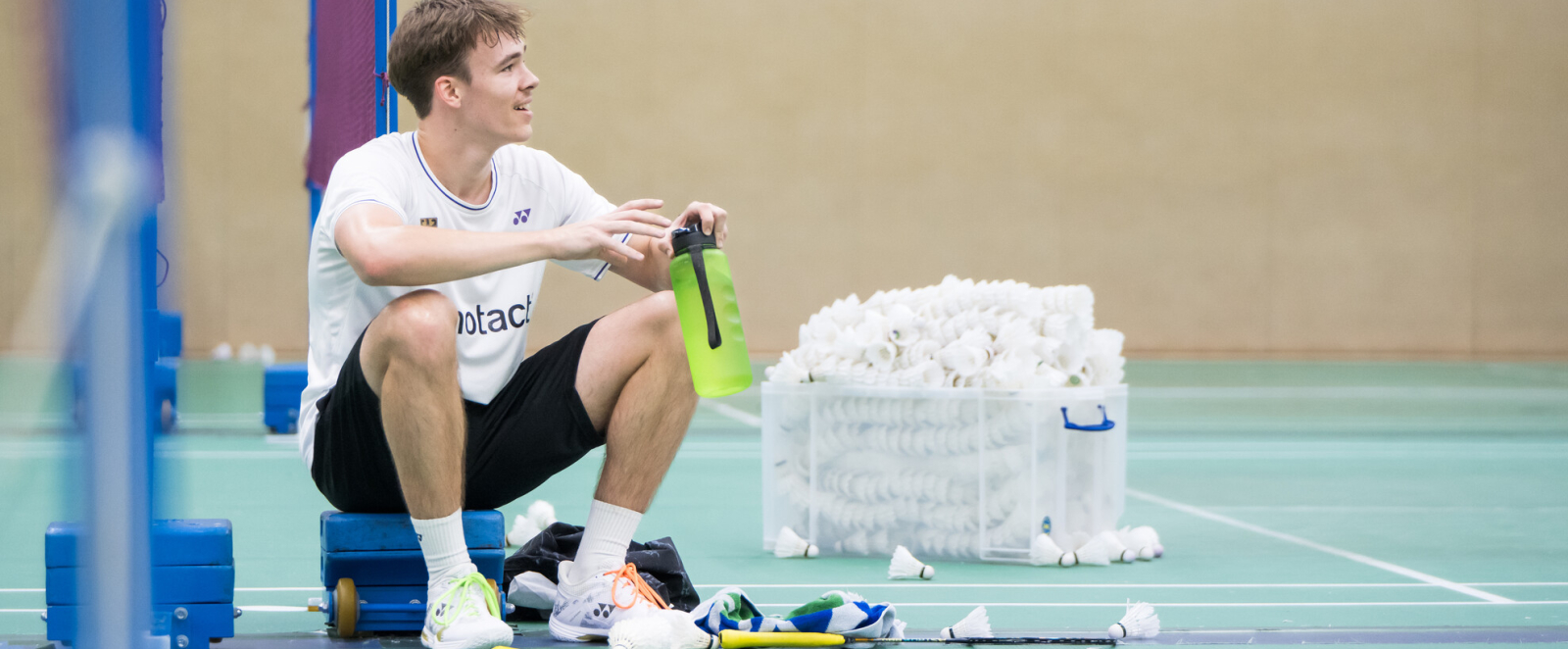 Linus Emmerich sitzt am Netz und schaut nach rechts