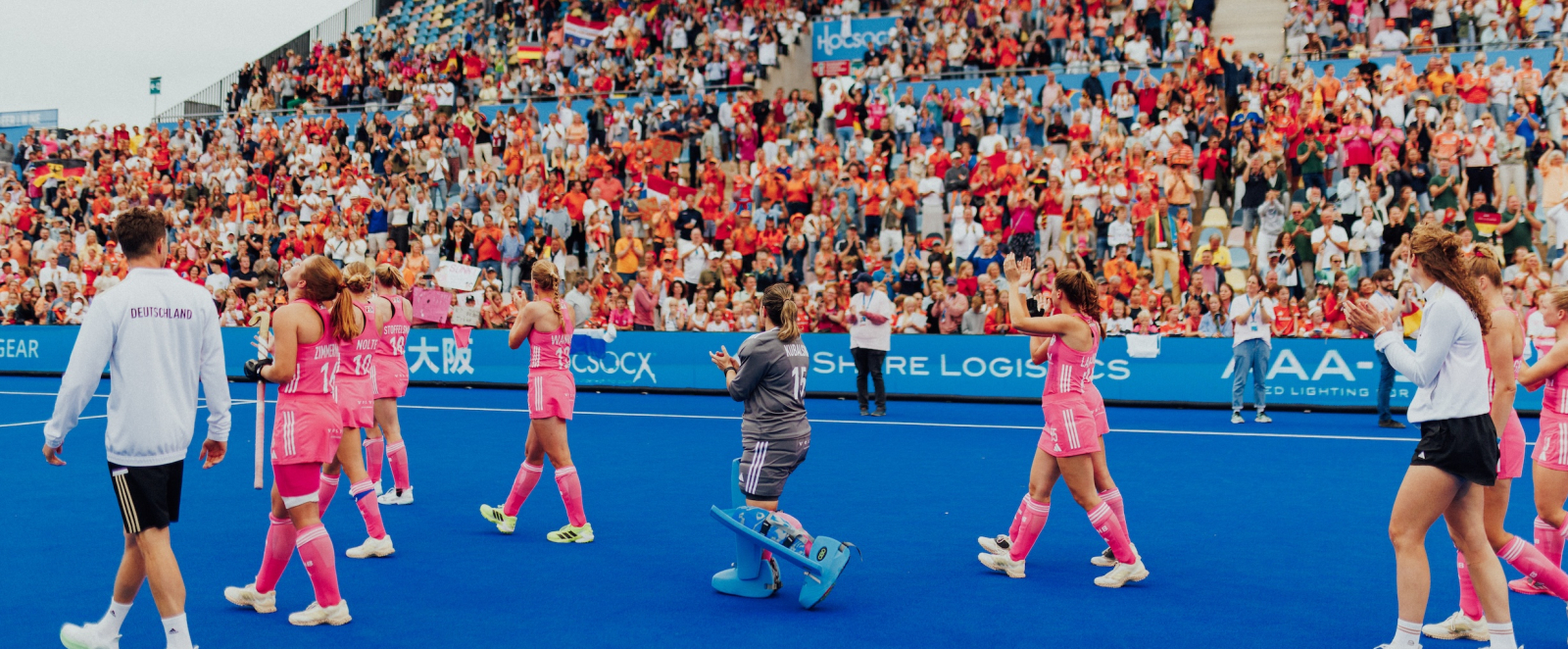 Hockeyspielerinnen vor der Tribüne