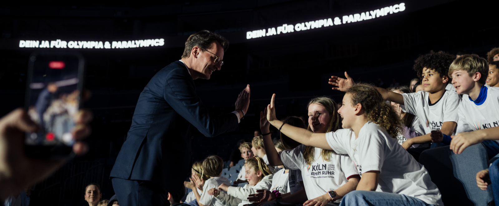 Ministerpräsident Wüst klatscht mit Kindern ab