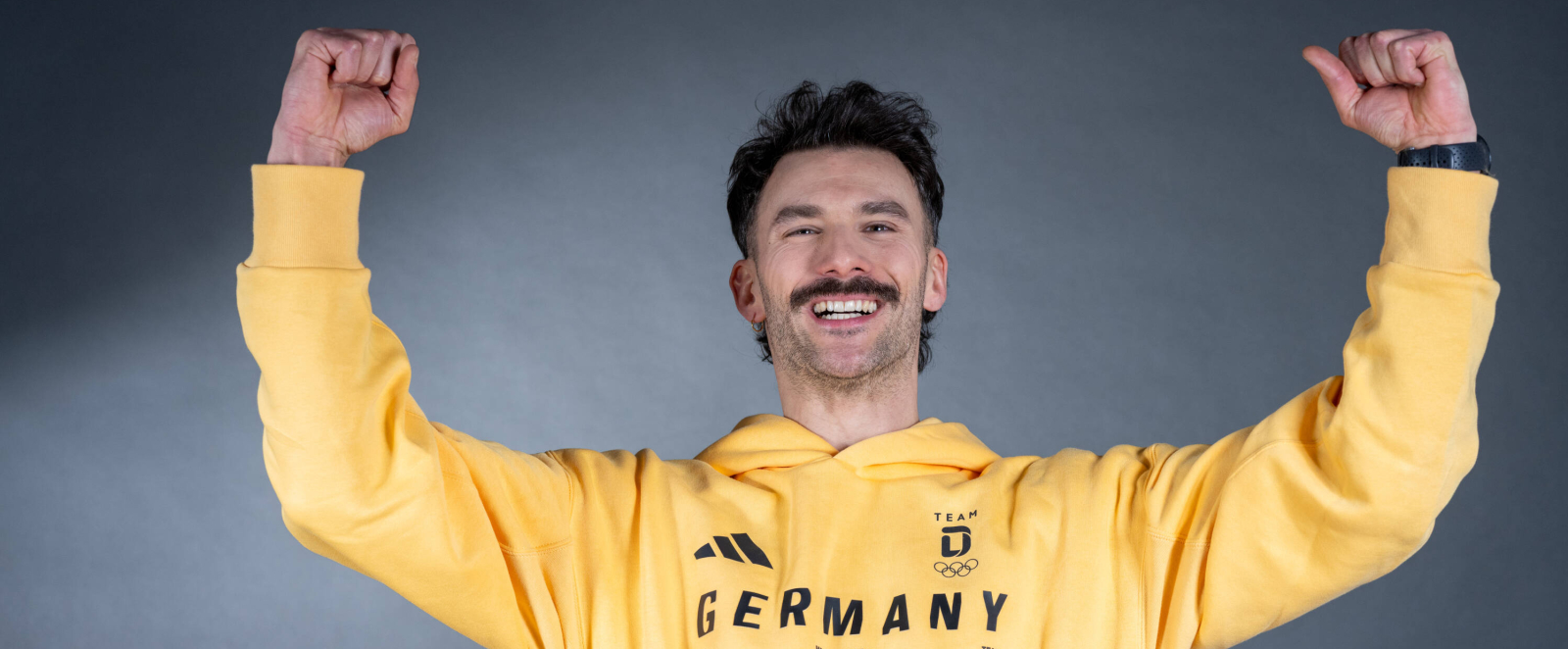 Axel Jungk in gelbem "Germany" Hoody vor dunklem Hintergrund