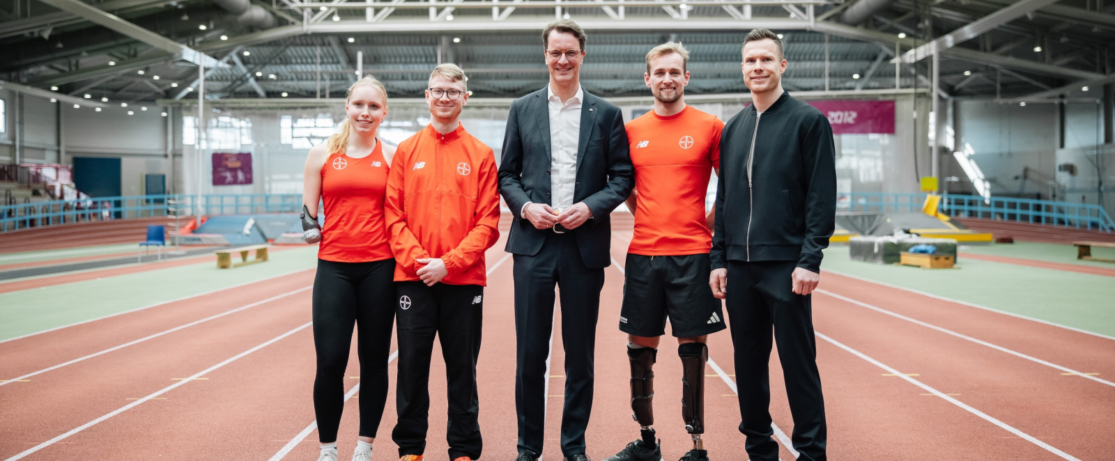 Ministerpräsident Wüst in der Trainingshalle in Leverkusen, umgeben von Markus Rehm, Johannes Floors sowie zwei weiteren Para Athleten