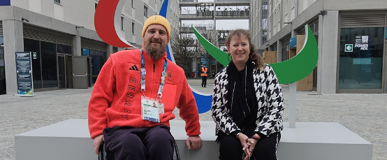 Andrea Milz und ein Para Athlet im Rollstuhl vor einer IPC Skulptur in Mailand