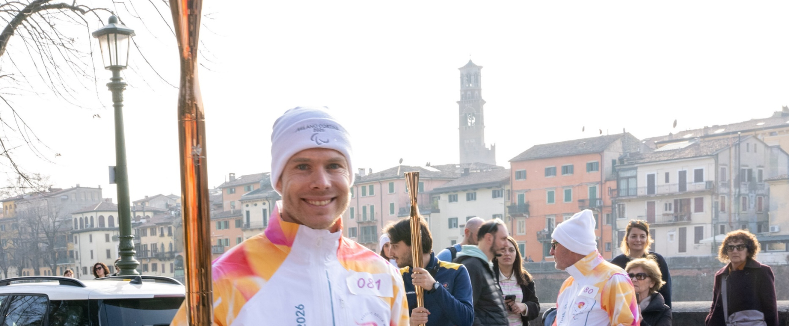 Markus Rehm in heller Kleidung trägt die Paralympics-Fackel