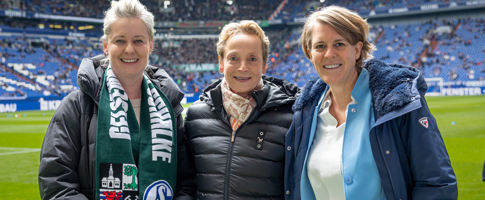 Drei Frauen auf dem Rasen, die für die Bewerbung KölnRheinRuhr werben