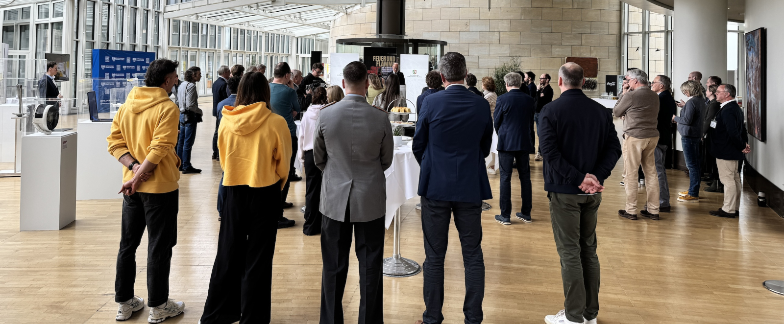 Teilnehmende an der Ausstellungseröffnung im Landtag unterhalten sich
