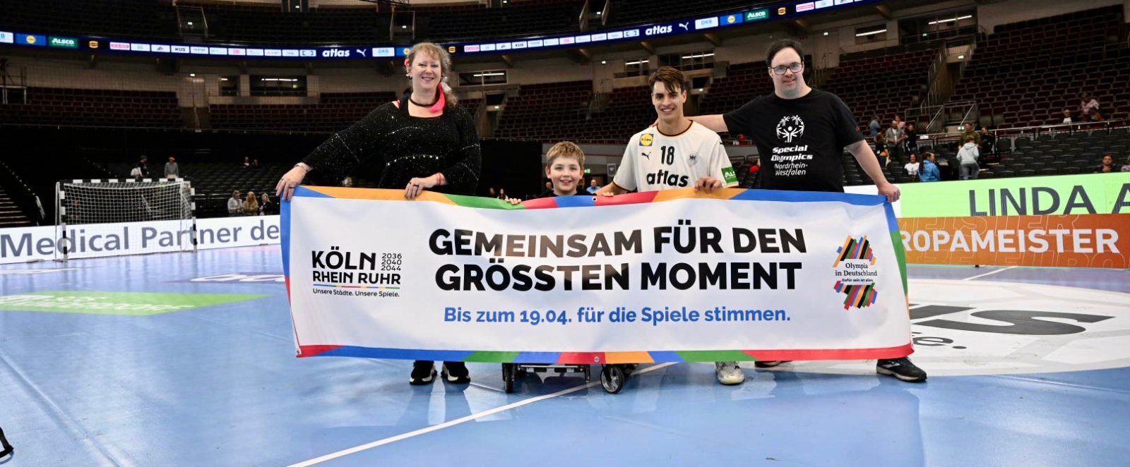 Andrea Milz, Julian Köster und zwei Jugendliche halten Banner der KRR-Bewerbung