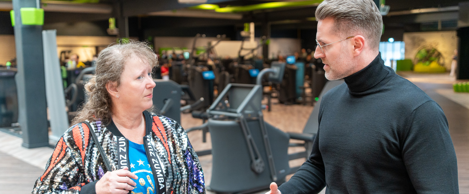 Andrea Milz und ein Mann im Gepräch in einem Fitnesstudio