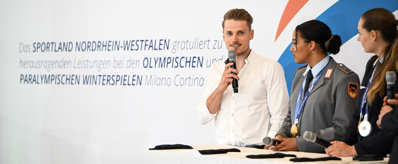 Sebastian Marburger am Mikrofon vor einem hellen Hintergrund