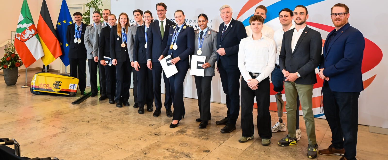Gruppe mit olympischen und paralympischen Sportlerinnen und Sportlern, in der Mitte Ministerpräsident Hendrik Wüst
