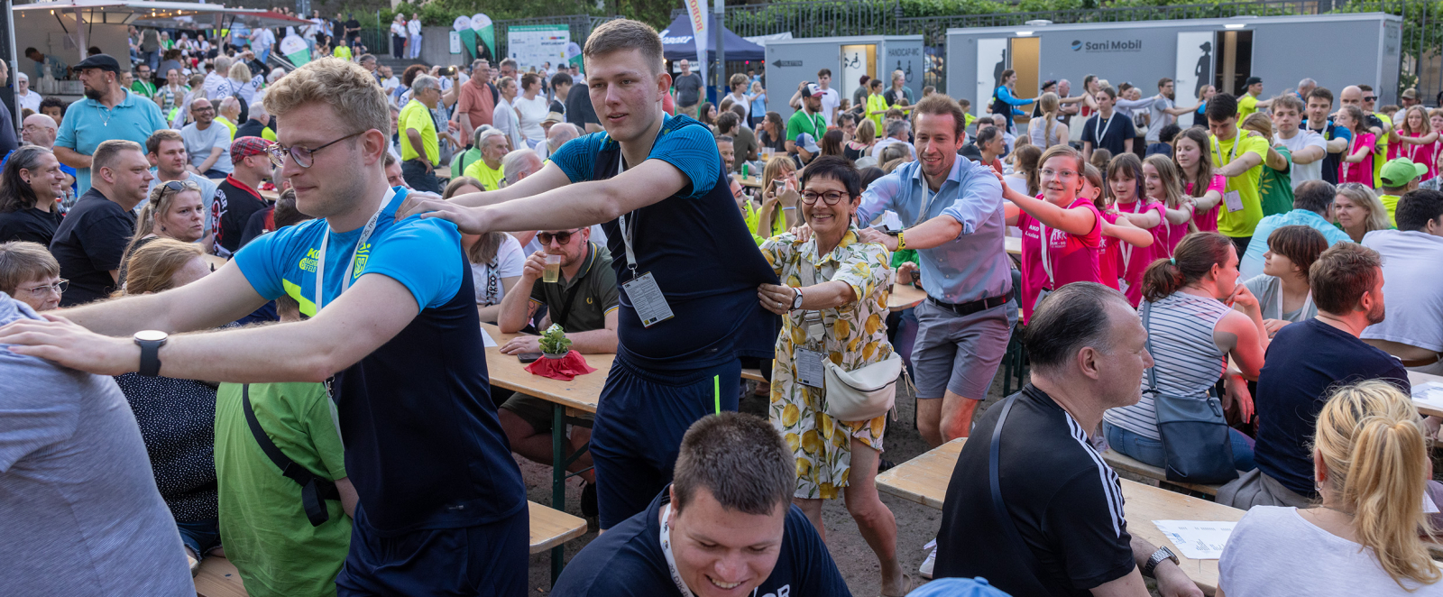 Blick auf eine Menschmenge beim Fest, mehrere Personen machen eine Polonaise