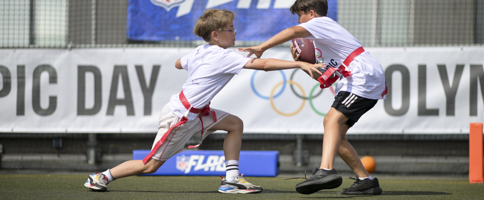 Zwei Jungen in weißen Shirts spielen Flag Football
