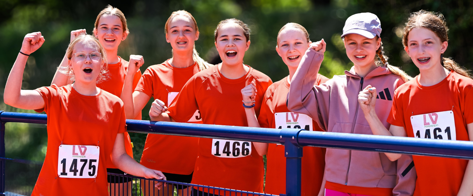 Junge Sportlerinnen in roter Bekleidung jubeln