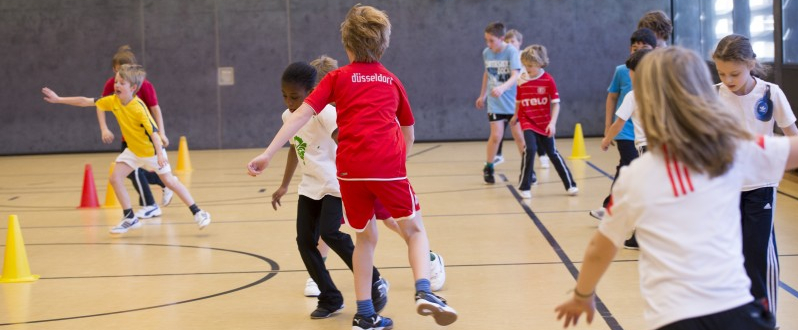 Viele Kinder in einer Sporthalle spielen miteinander