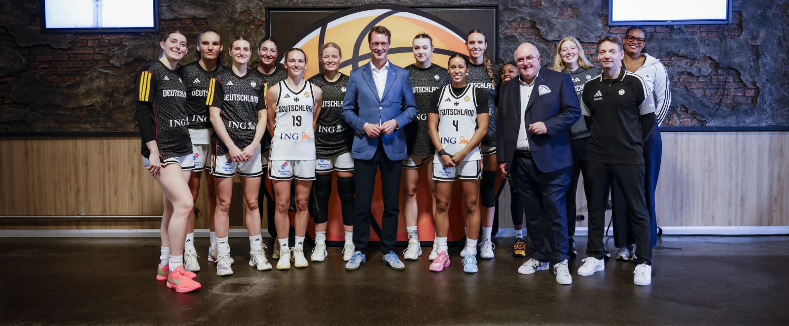 Ministerpräsident Wüst umgeben von Basketballerinnen