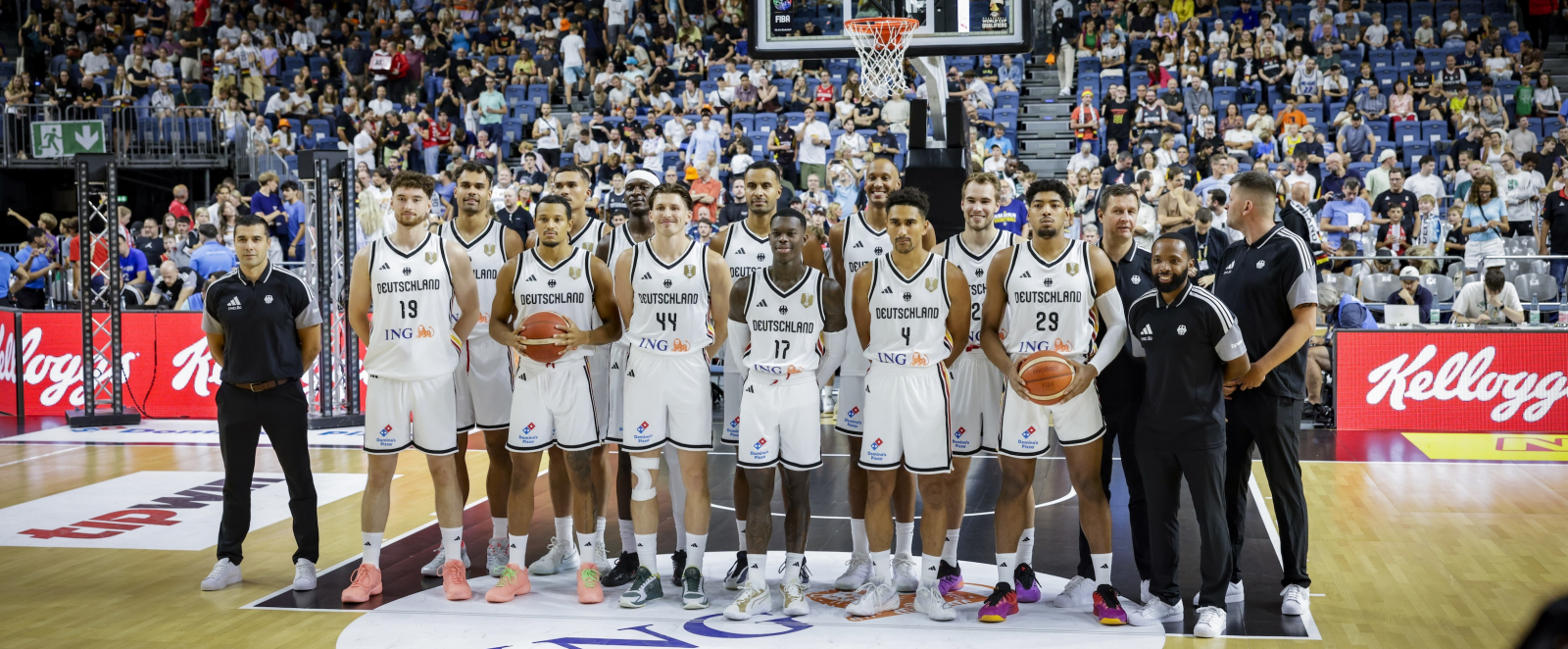 Aufstellung der Basketball-Nationalmannschaft auf dem Feld vor dem Korb