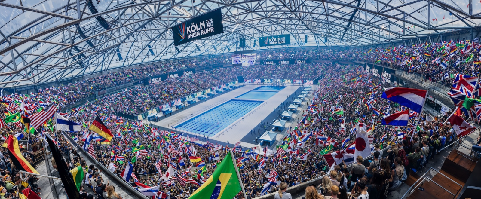 KI-Bild der Veltins Arena bei Olympischen Spielen mit einem Schwimmbecken in der Mitte und Fans drumherum