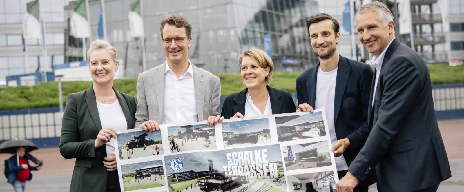 Ministerpräsident Wüst und weiter Personen halten ein Bild hoch