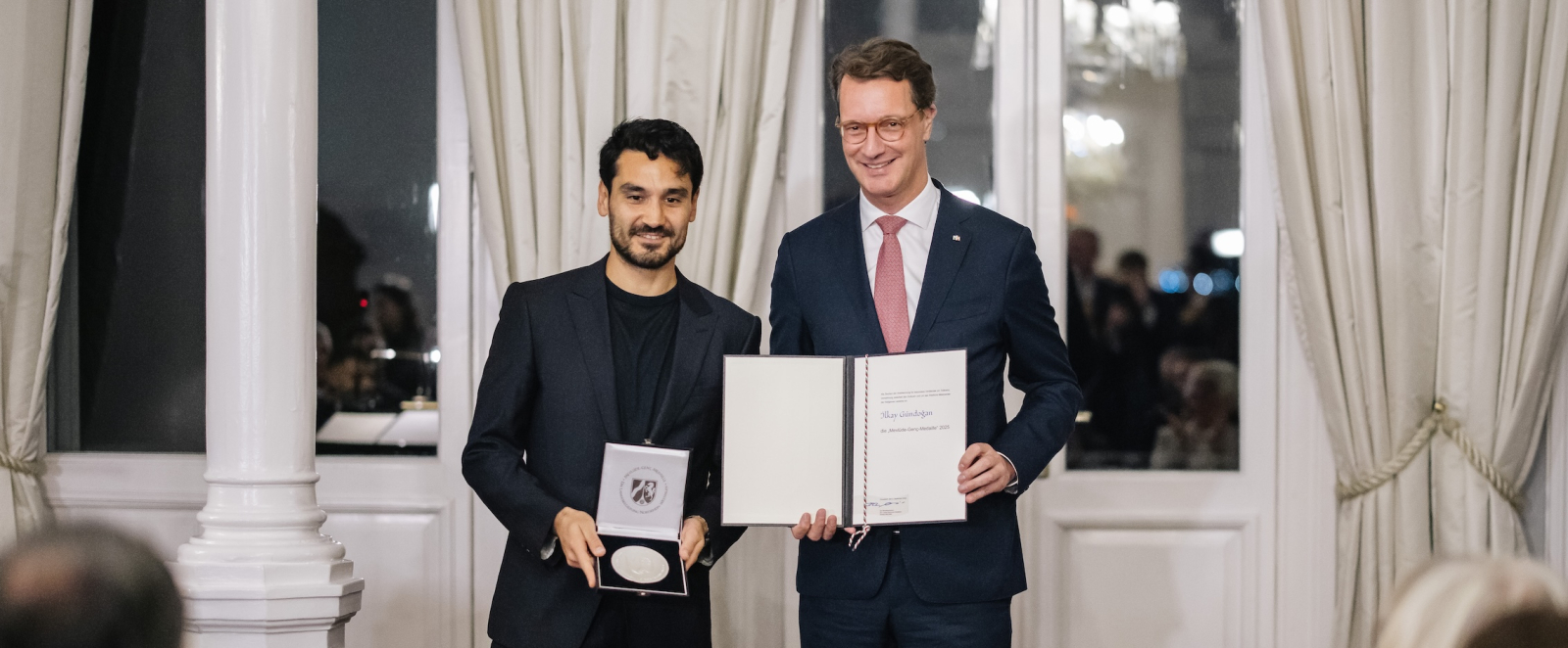 Ministerpräsident Wüst und Ilkay Gündogan mit Medaille und Auszeichnung