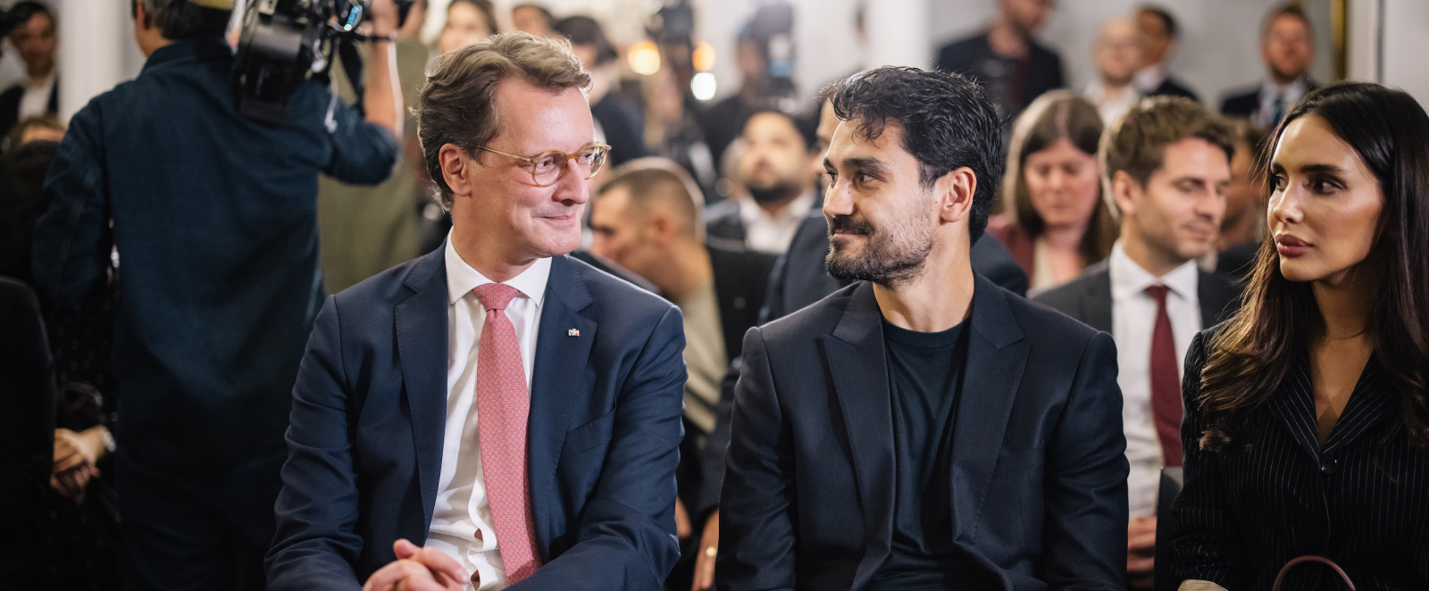 Ministerpräsident Wüst sitzt neben Ilkay Gündogan