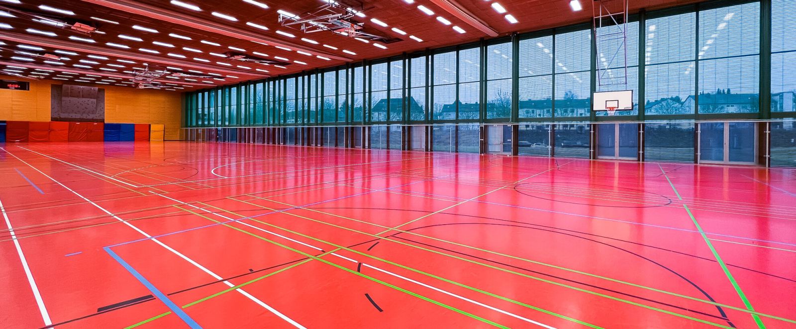 Blick in eine leere Sporthalle mit roten Boden