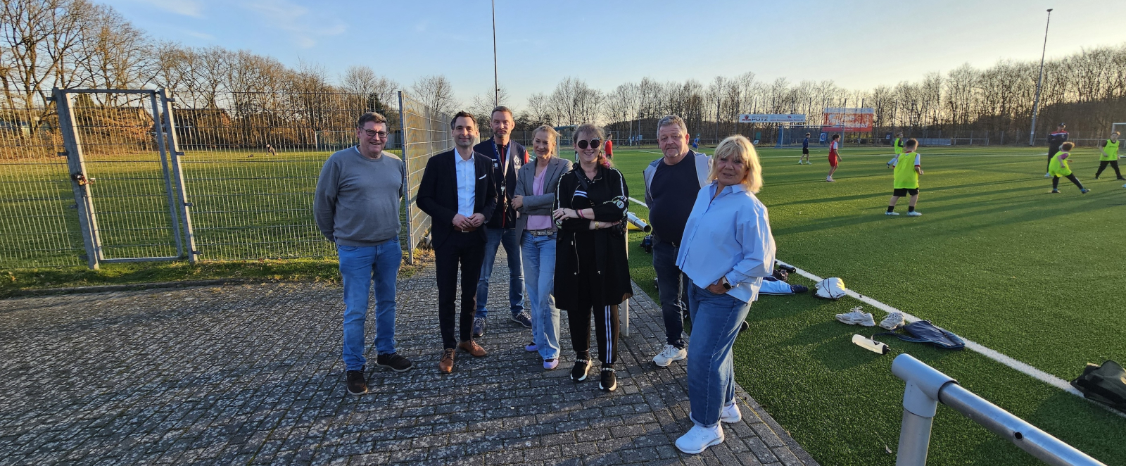 Gruppe von Menschen mit Andrea Milz iin der Mitte stehen auf einem Sportplatz