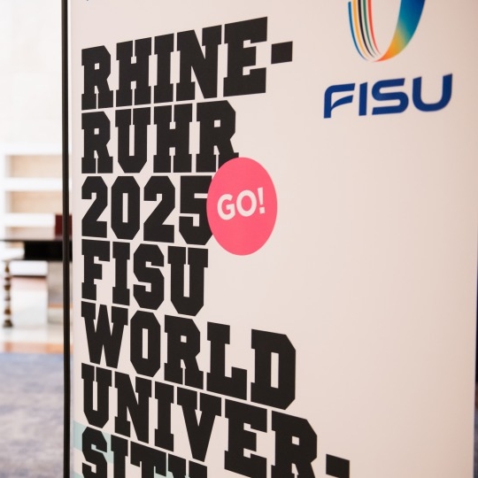 Plakat mit der Aufschrift RHINE-RUHR 2025 FISU WORLD UNIVERSITY GAMES