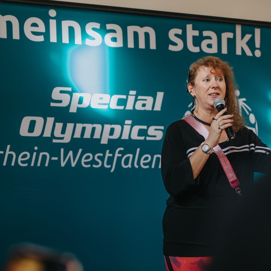 Andrea Milz vor Banner der Special Olympics NRW