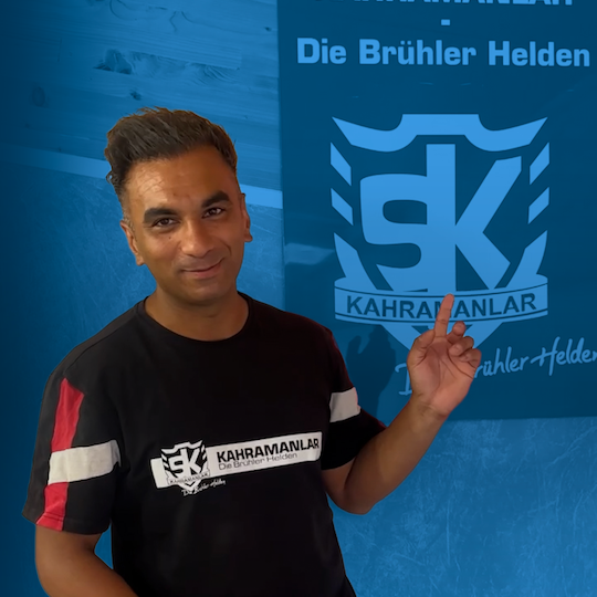 Foto von Fatih Türk vor blauem Hintergrund