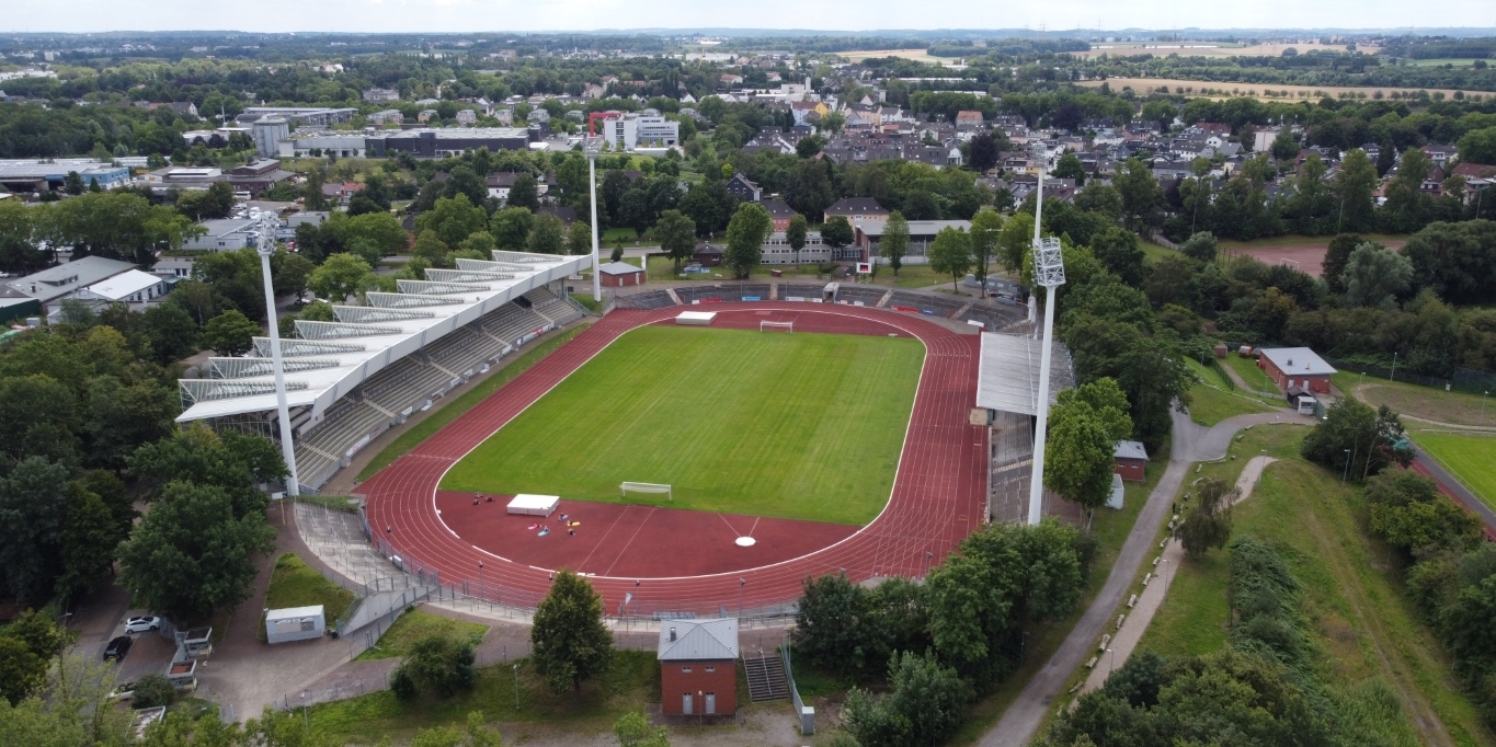Lohrheidestadion in Wattenscheid aus der Vogelperspektive. Ein offenes Stadion mit einem Fußball-Rasenplatz in der Mitte und umlaufenden Tartanbahnen, die Tribühnen sind teilweise überdacht.