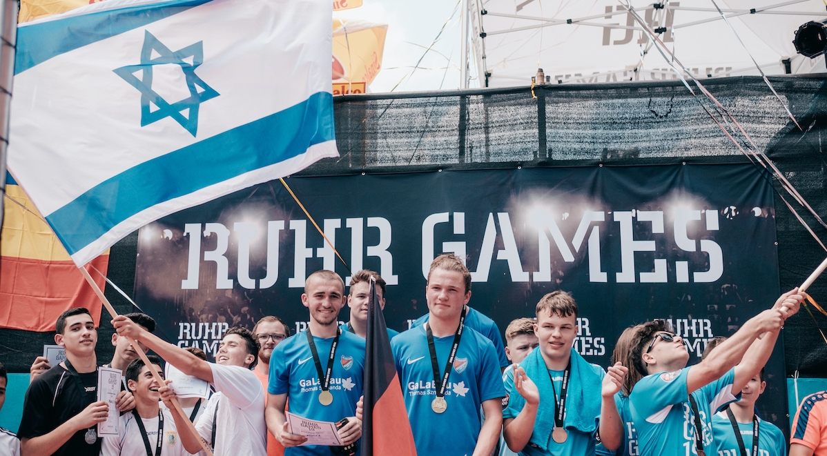 Sportlerinnen und Sportler bei den "Ruhr Games" mit schwenkenden Fahnen
