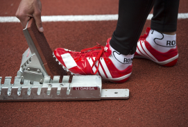 Sportler mit roten Schuhen präpariert den Startblock