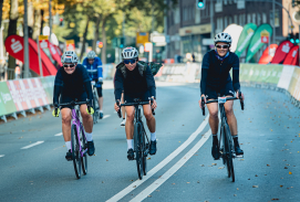 Drei Radsportler fahren nebeneinander auf der Straße