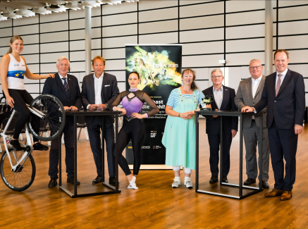 Gruppe mit 9 Personen vor dem Plakat des felix award